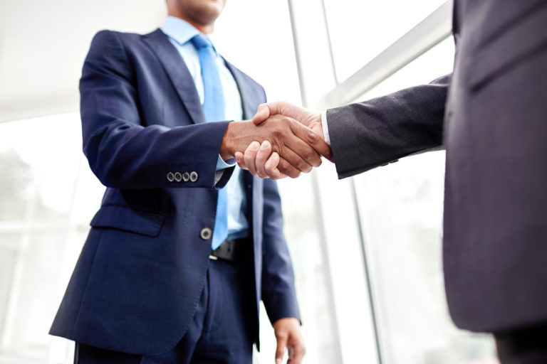 two businessmen shaking hands in agreement