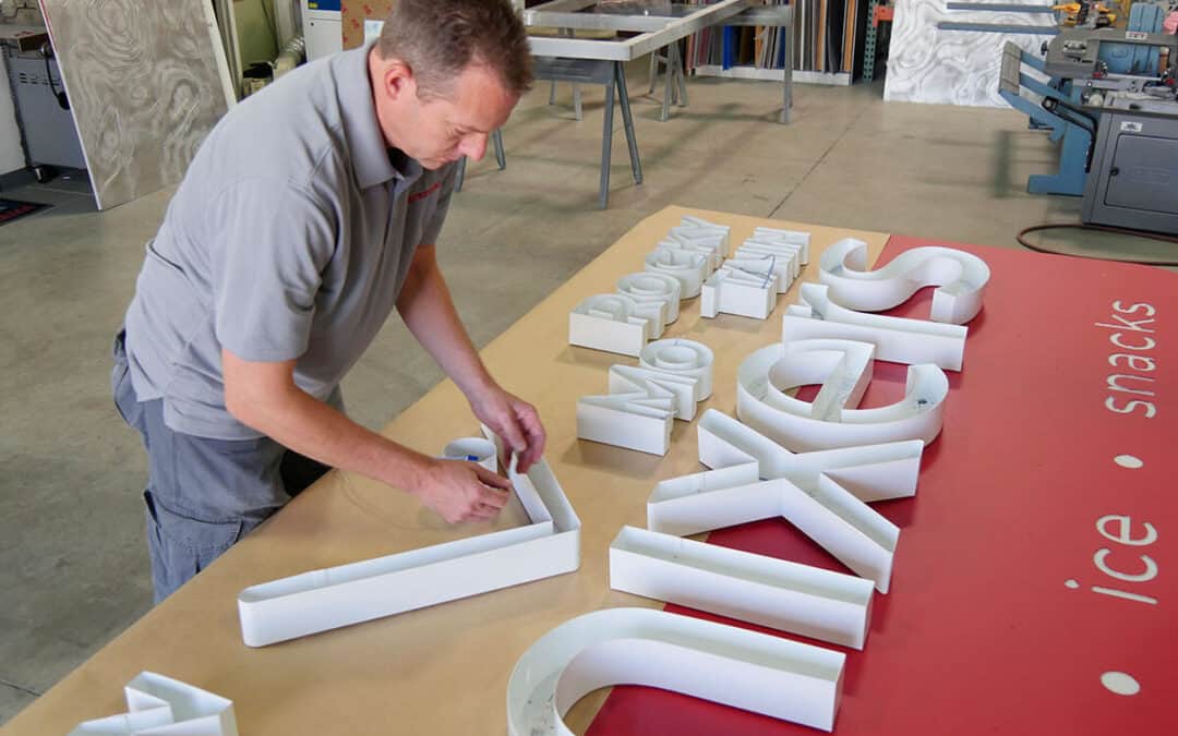 Signarama Franchise Staff Arranging Signage Letters